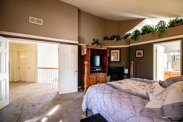 carpeted bedroom featuring high vaulted ceiling, a fireplace, and visible vents