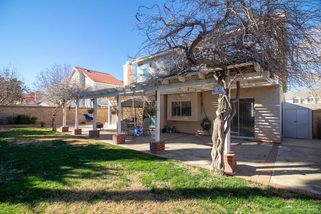 rear view of house with a patio, fence, a yard, a pergola, and stucco siding