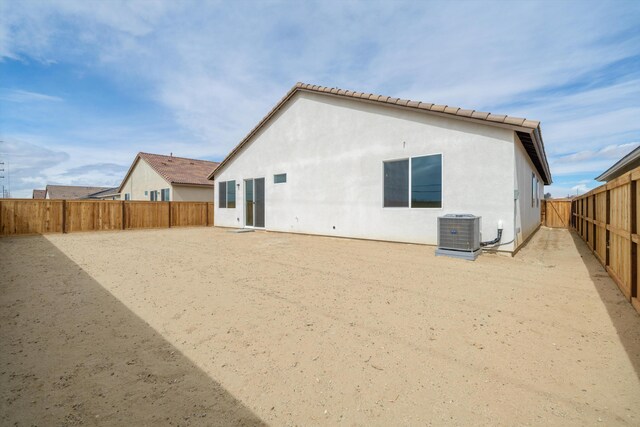 back of property featuring a fenced backyard, central AC unit, and stucco siding