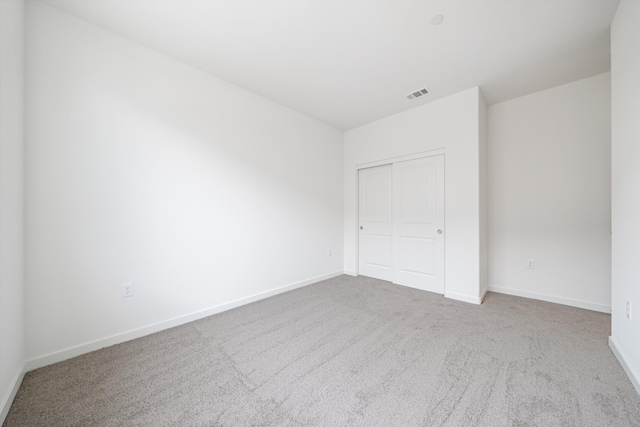 unfurnished bedroom with visible vents, carpet flooring, baseboards, and a closet