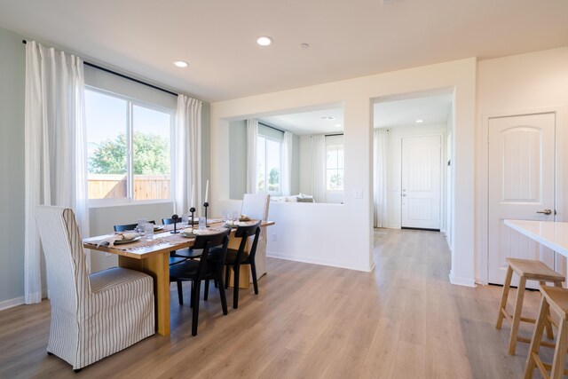 dining room with recessed lighting, baseboards, and light wood-type flooring
