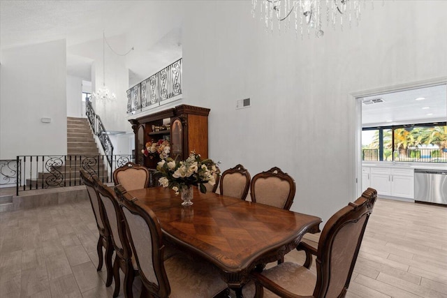 42722 W 20th St, Lancaster, CA 93534 - dining room featuring a chandelier, a towering ceiling, stairway, and light wood-style floors