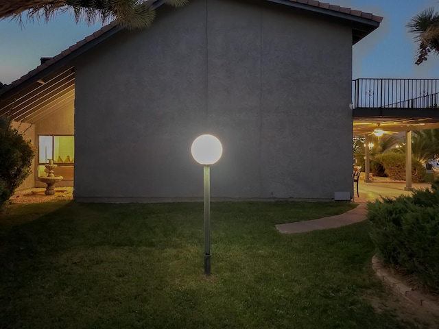42722 W 20th St, Lancaster, CA 93534 - view of side of home featuring a lawn, stucco siding, a tiled roof, and a balcony