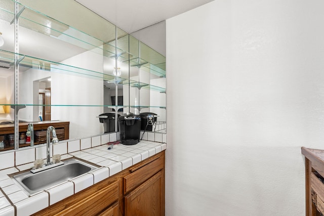 interior space with brown cabinets, a sink, and tile countertops