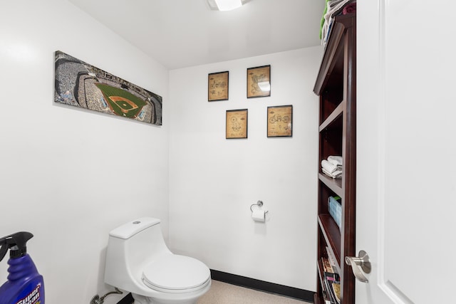 bathroom with toilet and baseboards