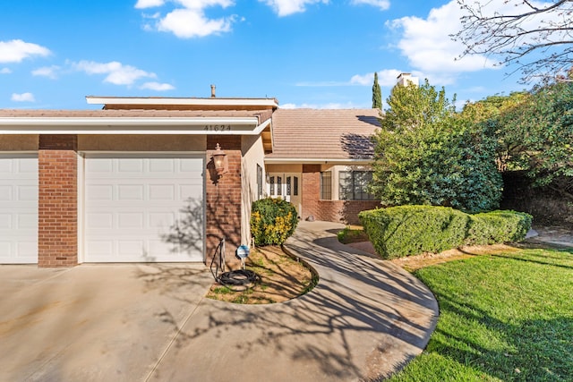 view of front of house featuring driveway, an attached garage, and brick siding