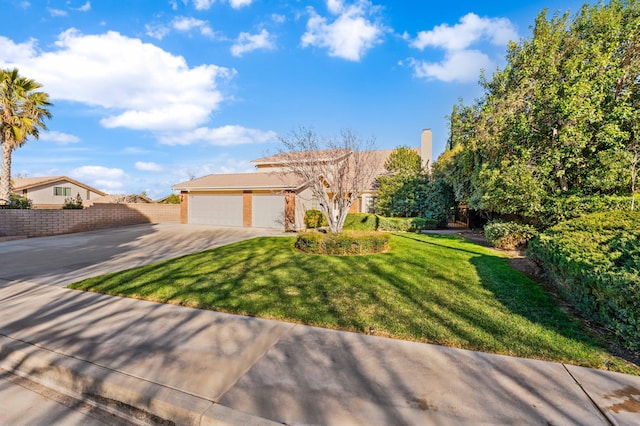 view of front of property featuring a front yard, driveway, an attached garage, and fence