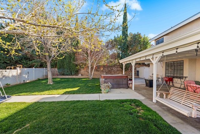 view of yard with a fenced backyard, a patio, and a hot tub