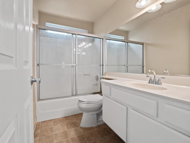 bathroom featuring toilet, vanity, and bath / shower combo with glass door