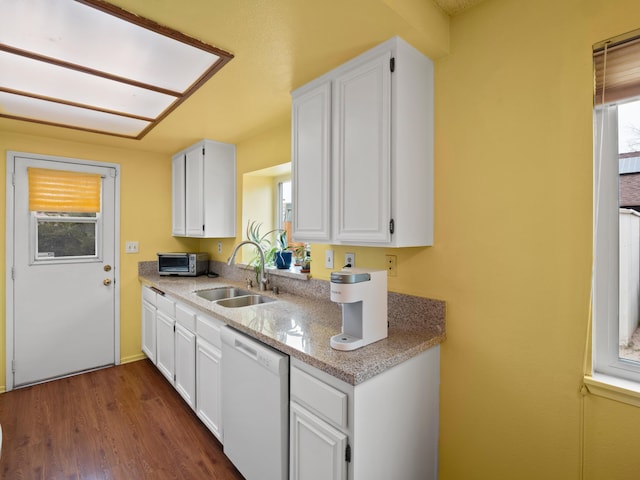 kitchen with dishwasher, white cabinetry, and a sink