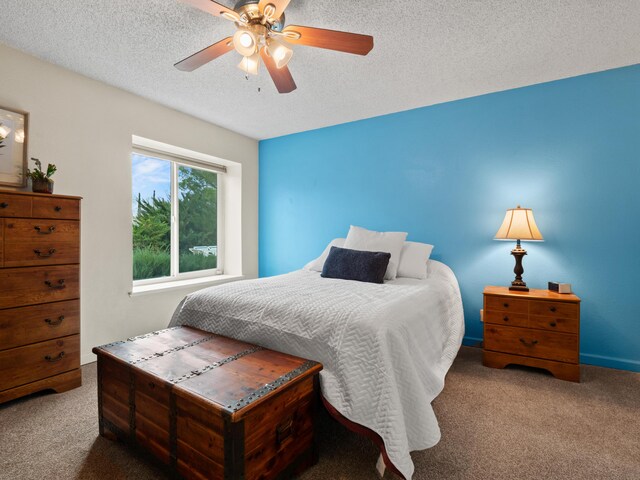 carpeted bedroom with ceiling fan and a textured ceiling