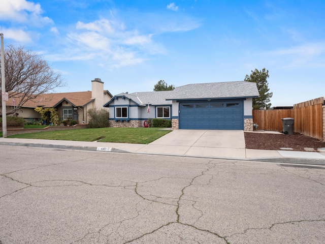 view of front facade with stucco siding, a front lawn, stone siding, fence, and an attached garage