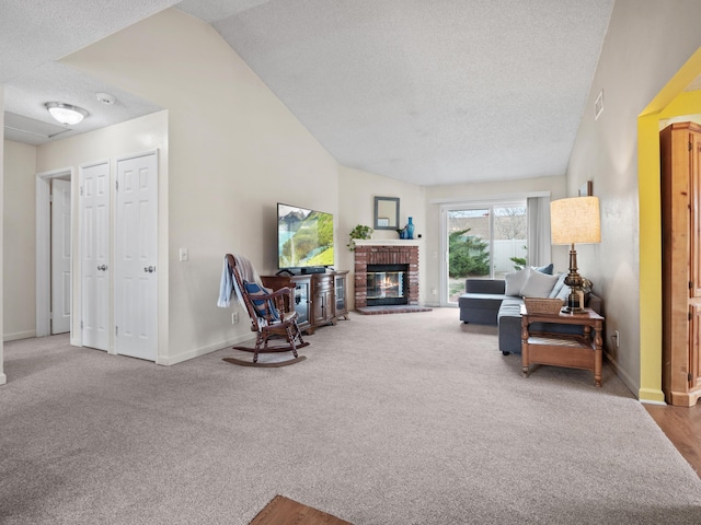 carpeted living area featuring visible vents, a textured ceiling, a fireplace, baseboards, and vaulted ceiling