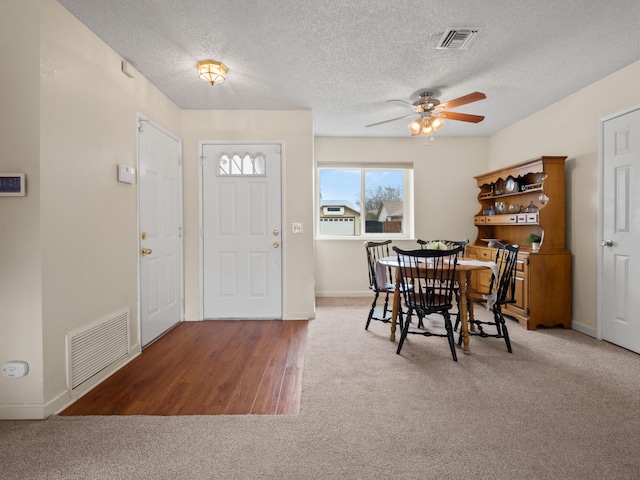 carpeted dining room featuring visible vents, ceiling fan, and baseboards