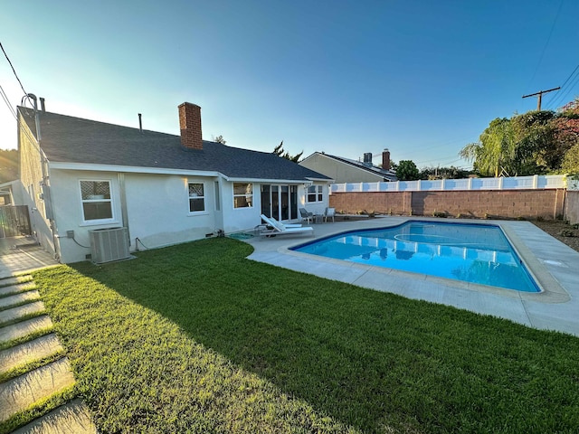 view of pool featuring a fenced in pool, central AC, a lawn, and a fenced backyard