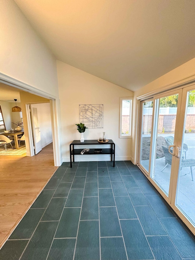 entryway with vaulted ceiling, french doors, dark wood finished floors, and baseboards