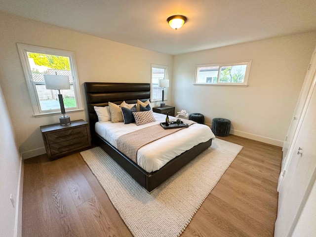 bedroom with baseboards and wood finished floors