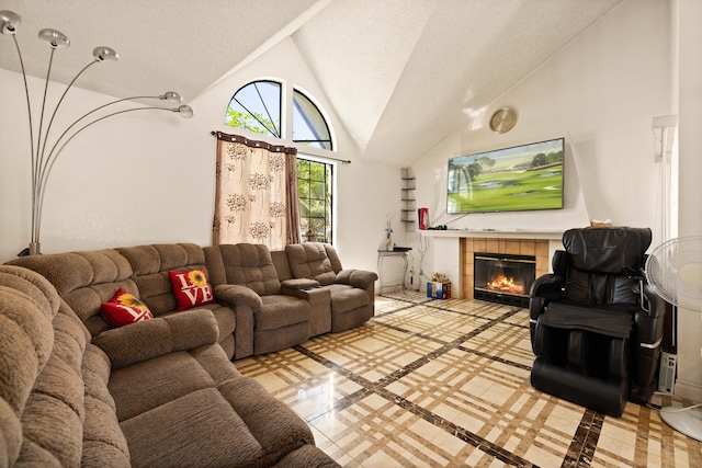 living room with high vaulted ceiling, a textured ceiling, and a fireplace