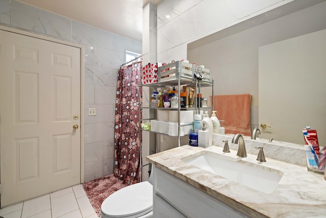 bathroom featuring tile walls, tile patterned flooring, a shower with shower curtain, vanity, and toilet