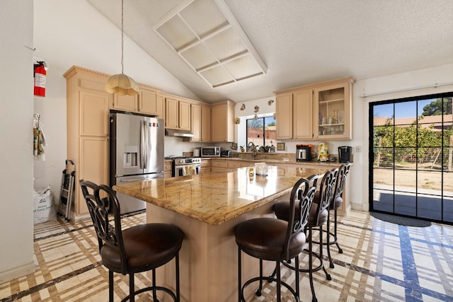 kitchen featuring a kitchen island, appliances with stainless steel finishes, a breakfast bar, pendant lighting, and lofted ceiling