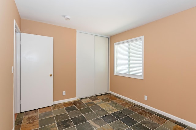 6310 Treehaven Ct, Lancaster, CA 93536 - unfurnished bedroom featuring stone tile floors and a closet