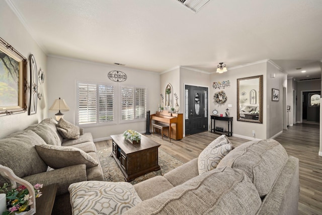 living room with light wood-type flooring and ornamental molding