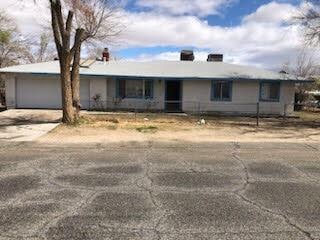 single story home with an attached garage and dirt driveway