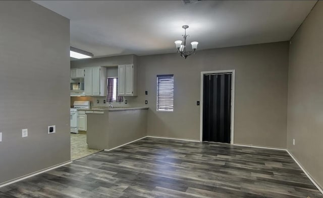 kitchen featuring dark hardwood / wood-style flooring, white range oven, a chandelier, white cabinetry, and hanging light fixtures