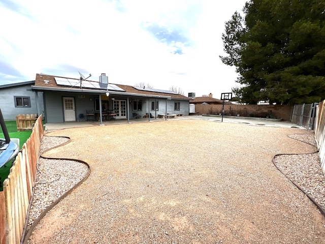 back of property featuring solar panels and a patio