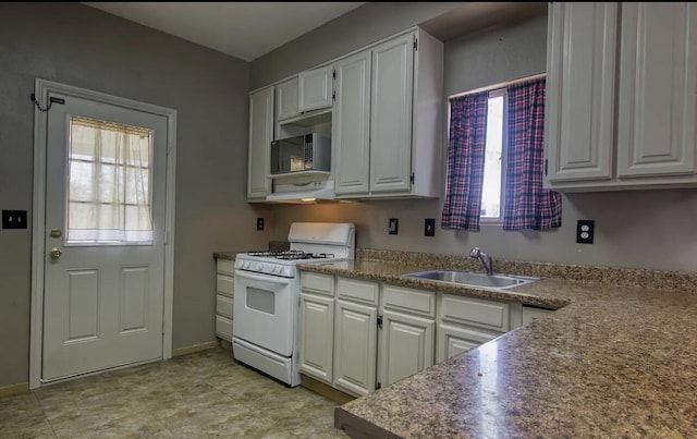 kitchen with white range with gas stovetop, range hood, white cabinetry, and sink