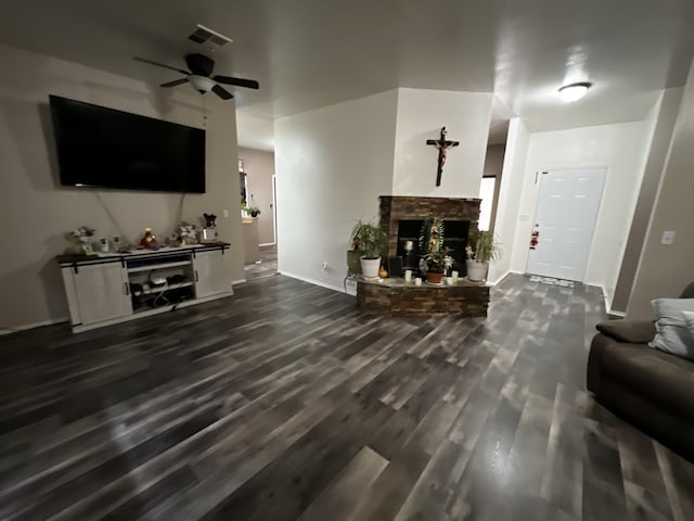 living room featuring ceiling fan, dark hardwood / wood-style flooring, and a brick fireplace