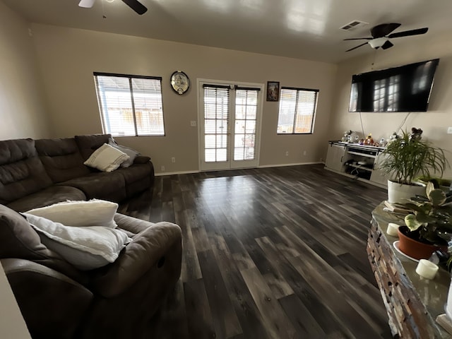 living room featuring ceiling fan, plenty of natural light, and dark wood-type flooring