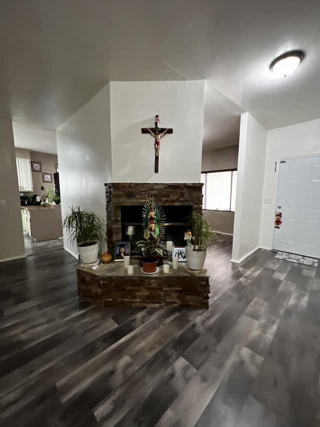 living room featuring dark hardwood / wood-style floors and a stone fireplace