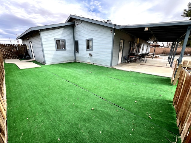 rear view of house with a patio and a lawn