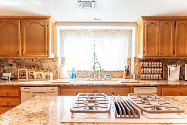43710 Shiloh Ln, Lancaster, CA 93535 - kitchen featuring white appliances, a textured ceiling, decorative backsplash, light stone counters, and brown cabinetry