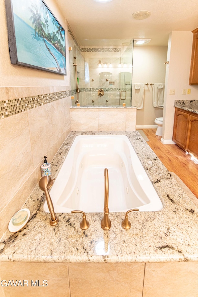 43710 Shiloh Ln, Lancaster, CA 93535 - full bathroom featuring a stall shower, vanity, a jetted tub, and wood finished floors