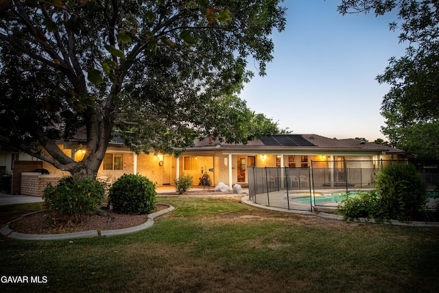 43710 Shiloh Ln, Lancaster, CA 93535 - rear view of house featuring solar panels and a lawn
