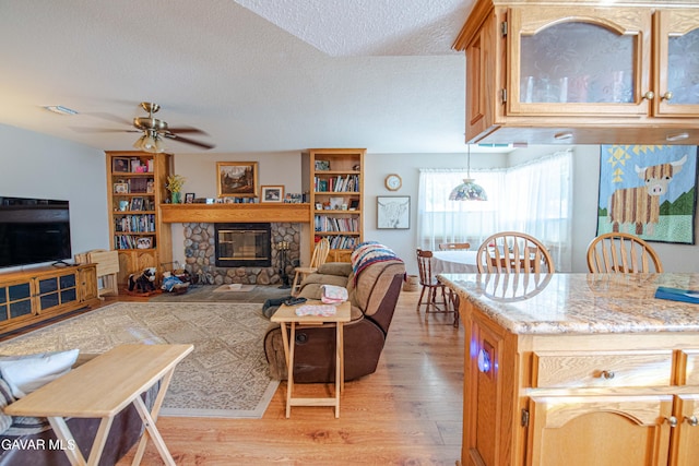 43710 Shiloh Ln, Lancaster, CA 93535 - living room featuring light wood finished floors, a ceiling fan, a textured ceiling, and a fireplace