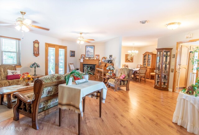 43710 Shiloh Ln, Lancaster, CA 93535 - dining area with a ceiling fan, light wood-style flooring, a glass covered fireplace, and a chandelier