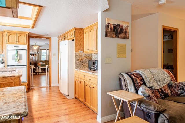 43710 Shiloh Ln, Lancaster, CA 93535 - kitchen featuring white appliances, light wood-style flooring, open floor plan, and decorative backsplash