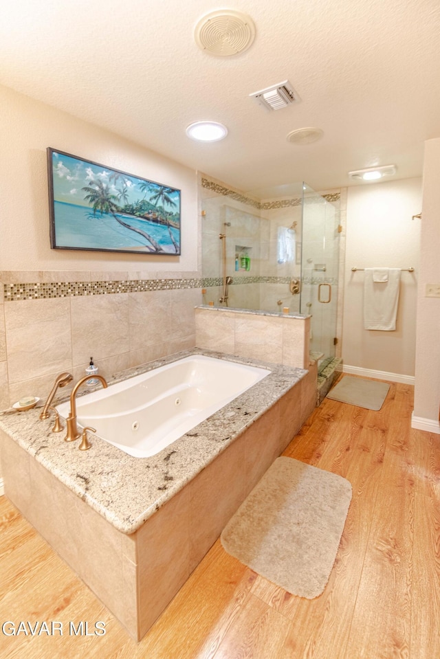 43710 Shiloh Ln, Lancaster, CA 93535 - full bath with wood finished floors, a stall shower, a tub with jets, and a textured ceiling