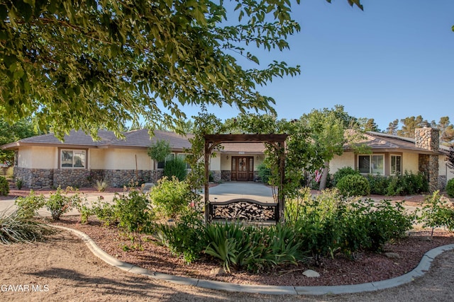 43710 Shiloh Ln, Lancaster, CA 93535 - view of front of property with stucco siding, stone siding, a chimney, a pergola, and a patio area