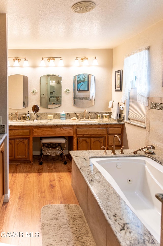 43710 Shiloh Ln, Lancaster, CA 93535 - full bath featuring wood finished floors, double vanity, a tub with jets, and a textured ceiling