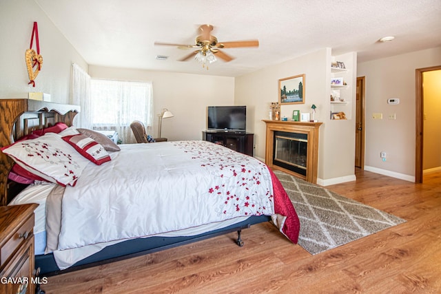 43710 Shiloh Ln, Lancaster, CA 93535 - bedroom featuring wood finished floors, a glass covered fireplace, and a ceiling fan