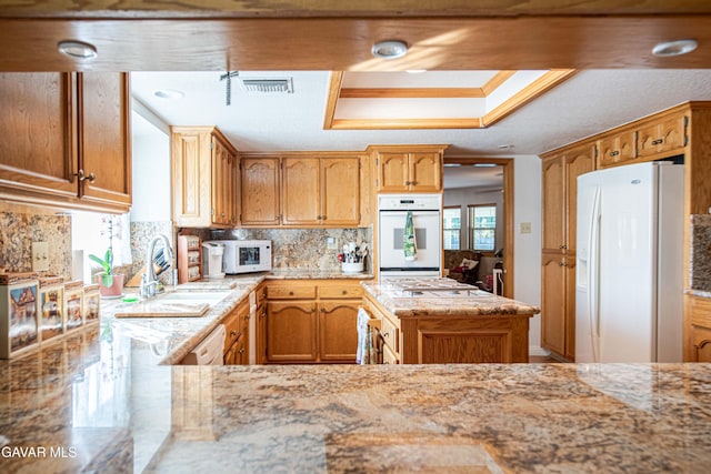 43710 Shiloh Ln, Lancaster, CA 93535 - kitchen featuring white appliances, decorative backsplash, light stone counters, and a kitchen island