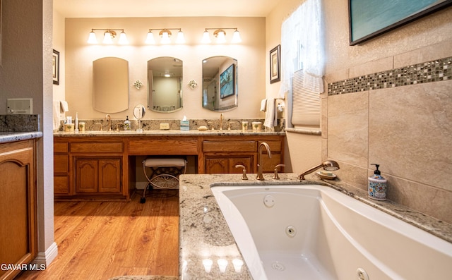 43710 Shiloh Ln, Lancaster, CA 93535 - bathroom featuring a tub with jets, double vanity, and wood finished floors