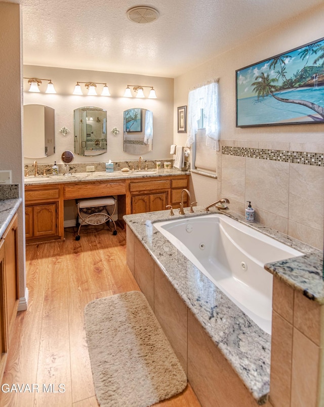 43710 Shiloh Ln, Lancaster, CA 93535 - full bath featuring double vanity, wood finished floors, a tub with jets, and a textured ceiling