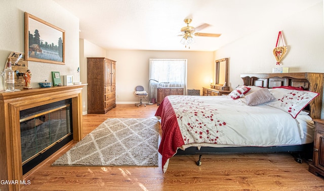 43710 Shiloh Ln, Lancaster, CA 93535 - bedroom with wood finished floors, a glass covered fireplace, and ceiling fan