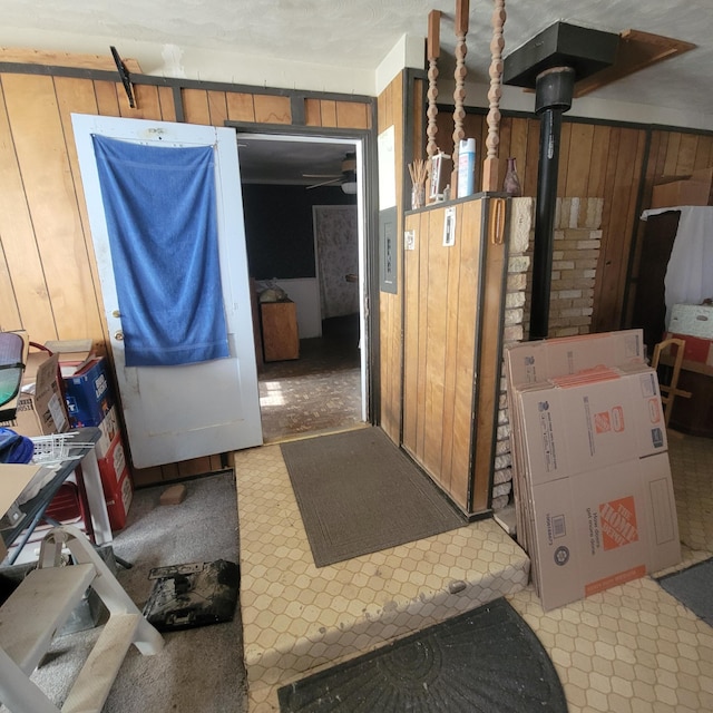 basement featuring a wood stove and wood walls