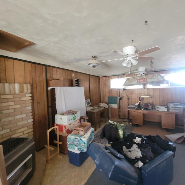 interior space featuring ceiling fan and wood walls